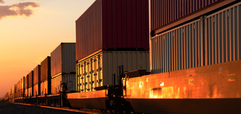train with double stacked containers at sunset