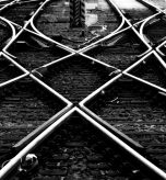 Railway track panorama at Frankfurt Main Station Germany. Geometrical lines in black and white. Contrasting steel of switches, crossings, railway sleepers, gravel forming symmetrical structures.