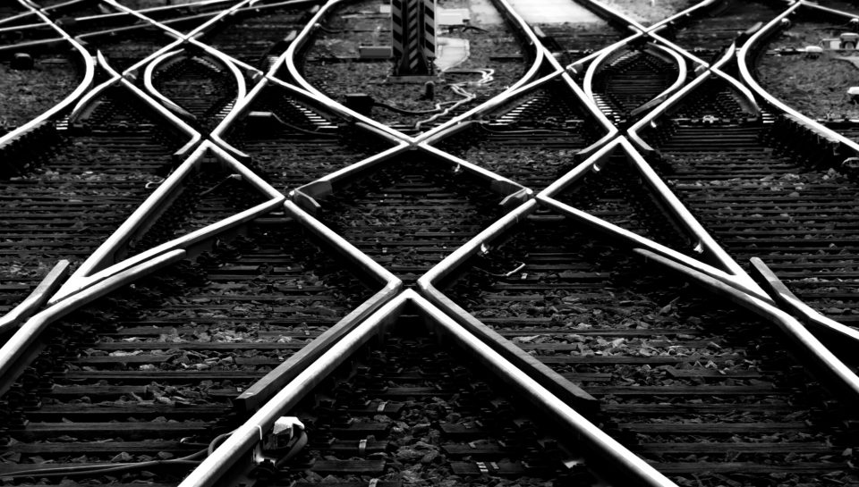 Railway track panorama at Frankfurt Main Station Germany. Geometrical lines in black and white. Contrasting steel of switches, crossings, railway sleepers, gravel forming symmetrical structures.