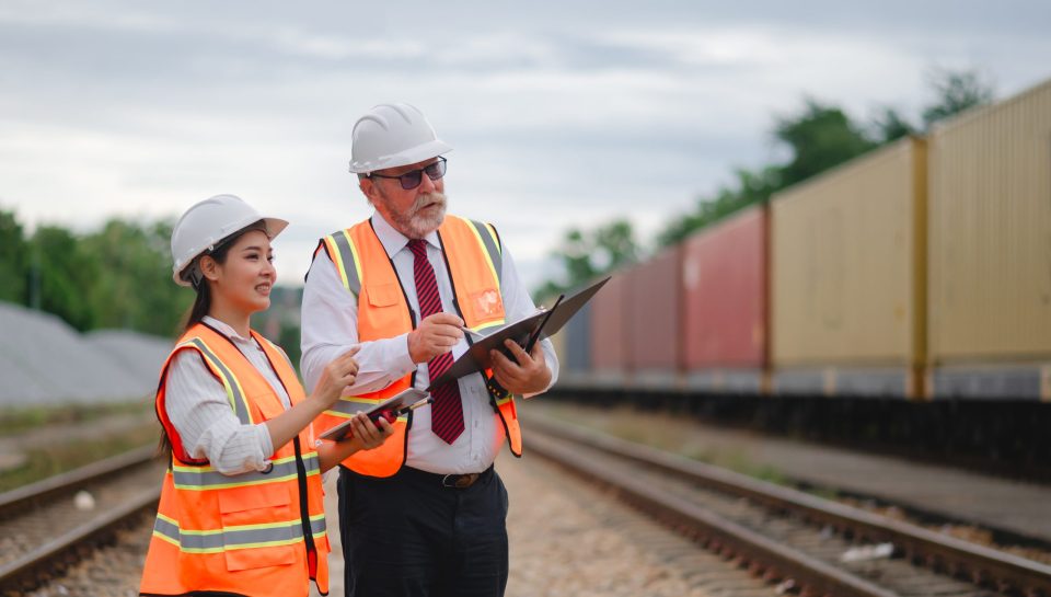 Engineer manager and a secretary working together railway track during inspection or routine maintenance gas or oil power industrial or transportation setting the rail train import export logistics.